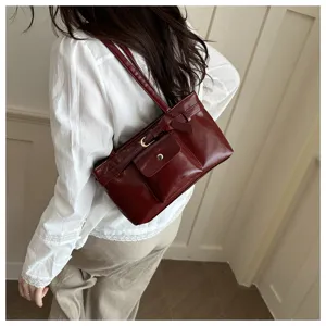 Retro burgundy large capacity shoulder bag with front buckle pocket detail worn on shoulder