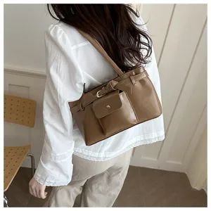 Side view of a retro brown soft leather tote bag with a decorative buckle on model