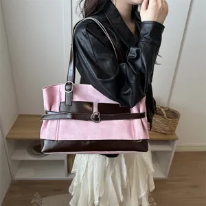 Sac cabas de niche élégant rose et marron avec boucle en cœur porté par un modèle.