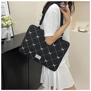 Sac fourre-tout noir pour ordinateur avec broderie quadrillée et nœuds sur mannequin