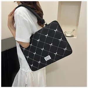 Sac à bandoulière noir matelassé pour ordinateur avec broderies nœuds élégants.