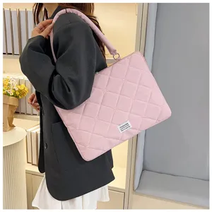 Femme portant une élégante sacoche d'ordinateur rose matelassée avec des broderies