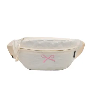 Cremeweiße Gürteltasche mit rosa bestickter Schleife und verstellbarem Gurt