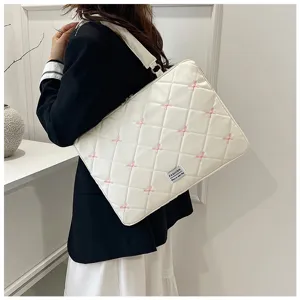 Sacoche matelassée blanche pour ordinateur avec broderies nœuds roses, vue lifestyle
