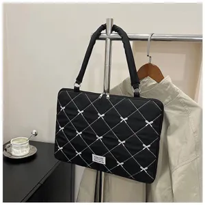 Vue rapprochée détaillée du sac d'ordinateur portable noir matelassé à motifs de nœuds