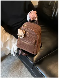 Nahaufnahme eines Vintage-Rucksacks mit Leopardenmuster und Hello Kitty Plüsch-Anhänger für Damen