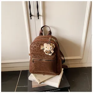 Detail eines Vintage-Rucksacks mit Leopardenmuster und süßem Katzenanhänger