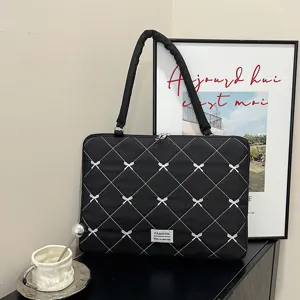 Sac fourre-tout noir matelassé pour ordinateur avec motif grille et détails de nœuds
