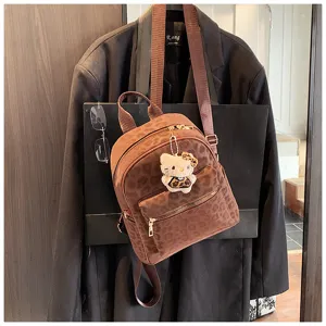 Detailansicht eines braunen Vintage-Rucksacks mit Leopardenmuster und Hello-Kitty-Anhänger