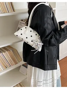 Trendy white polka dot bowling bag with silver star charm worn as an underarm bag