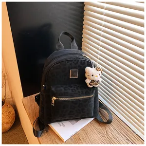 Detailansicht eines schwarzen Rucksacks mit Leopardenmuster und niedlichem Anhänger
