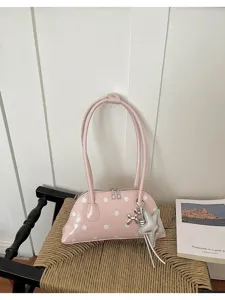 Detail view of pink polka dot bowling bag with silver star and balloon dog charms