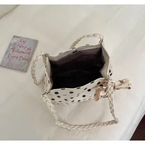 Draufsicht auf eine Polka-Dot-Tasche mit geräumigem Innenraum und geflochtenen Griffen