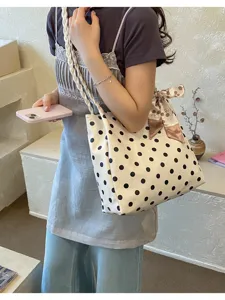 Detailansicht der weißen Polka-Dot-Tasche mit geflochtenem Riemen und Blumenschleife