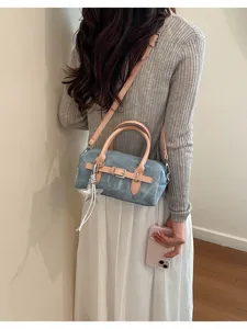 Female model wearing a vintage denim pillow bag with pink leather straps and star charm