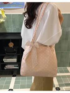 Detailed shot of the pink polka dot tote bag with a decorative bow and braided strap