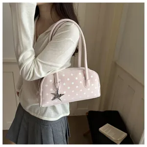 Close-up of a cute pink polka dot pillow handbag with a starfish charm detail