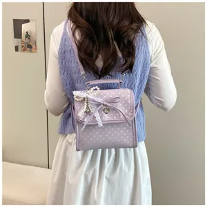 Sweet purple polka dot backpack with lace and pearl details worn by a model
