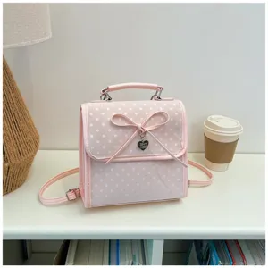 Front detail of sweet pink polka dot backpack with leather bow and heart charm decoration