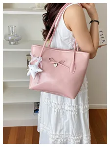 Elegant pink faux leather tote bag carried by a model in a bright minimalist room