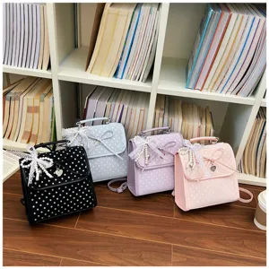 Detail of cute polka dot backpacks in 4 colors with lace bows and pearl charms on a shelf