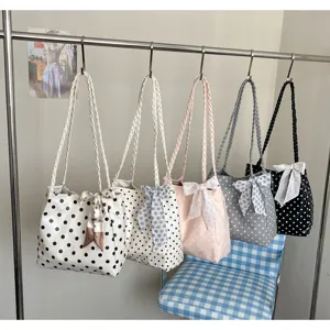 Variety of Korean style polka-dot tote bags with ribbon bows hanging on a metal rack.