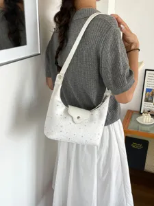 Détail d'un sac à bandoulière blanc en demi-lune avec motif d'étoiles et design chic.