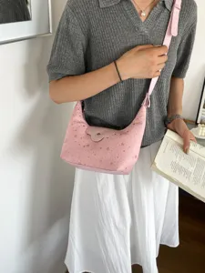 Mannequin portant un sac hobo rose à motif étoiles, idéal pour une tenue d'été décontractée.