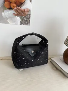 Sac à main croissant noir chic avec motifs étoiles argentées dans un décor élégant