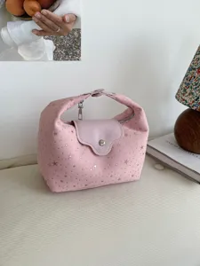 Sac à main rose en forme de croissant avec motif d'étoiles et rabat dans un décor chaleureux.