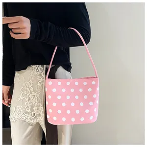 Bolso tipo cubo rosa con lunares blancos al hombro para un estilo casual sencillo