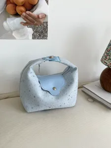 Vue détaillée d'un sac demi-lune bleu clair avec motif d'étoiles dans un décor chic