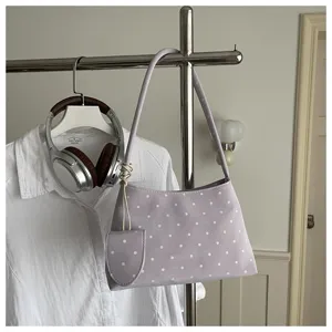 Bolso de hombro lavanda con lunares blancos y detalle de mini monedero a juego.