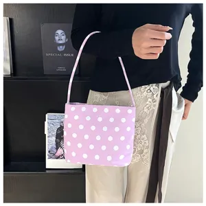Detalle de un bolso de mano lila con lunares combinado con ropa informal