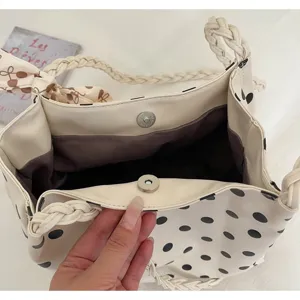 Close-up detail of beige polka dot tote bag showing interior lining and magnetic snap
