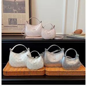 Vue détaillée des mini sacs à bandoulière à pois et nœuds en rose, blanc et argent