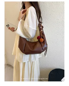 Stylish retro brown faux leather dumpling shoulder bag for women with pom-pom charm
