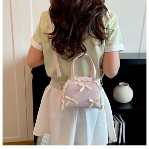 Detailansicht einer rosa gepunkteten Handtasche mit Spitze und Schleifen an einem Modell