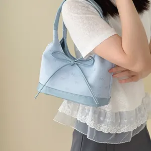 Elegante borsa sottobraccio azzurra da donna con fiocco decorativo e ricami a fantasia