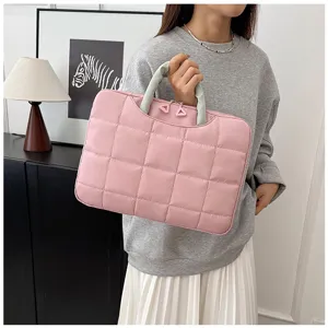 Borsa trapuntata rosa per laptop da 14 pollici tenuta da una modella in posa