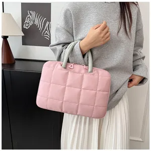 Primo piano dettagliato di una borsa per laptop rosa trapuntata da donna.