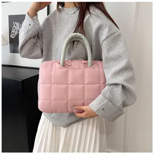 Elegante borsa trapuntata rosa per laptop da donna mostrata in un contesto casual