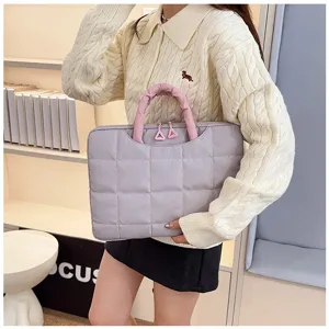 Dettaglio della borsa per laptop viola imbottita con manici arricciati rosa e cerniere