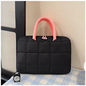 Vista dettagliata della borsa per laptop nera trapuntata con manici rosa imbottiti