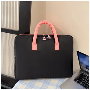 Vista ravvicinata di una borsa per laptop imbottita nera e rosa su una scrivania