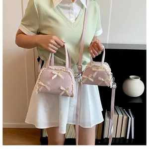 Detailansicht der rosa gepunkteten Handtasche mit Spitze und Schleifenakzenten.