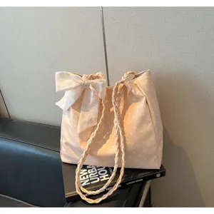 Polka dot tote bag with decorative bow and braided straps on lifestyle setting