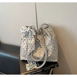 Elegant women's gray polka dot tote bag featuring a bow detail and braided straps