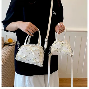 Detail der weißen Handtaschen mit Spitzen-Punkten, Größenvergleich und Schleifen-Akzenten