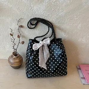 Large capacity polka dot tote bag with decorative floral bow and braided shoulder straps.